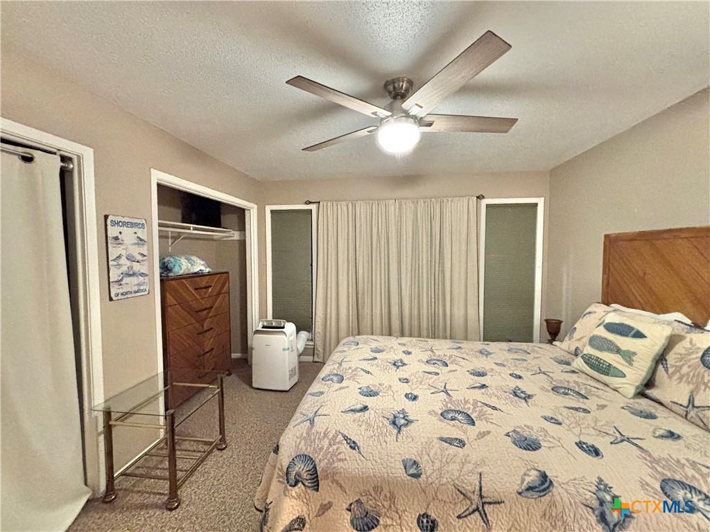454 15th Street Port O'Connor, TX 77982 - Photo 33 of 45 a bedroom with a large bed and a chandelier