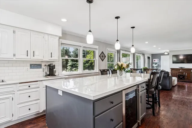 a kitchen with granite countertop a stove a sink a dining table and chairs