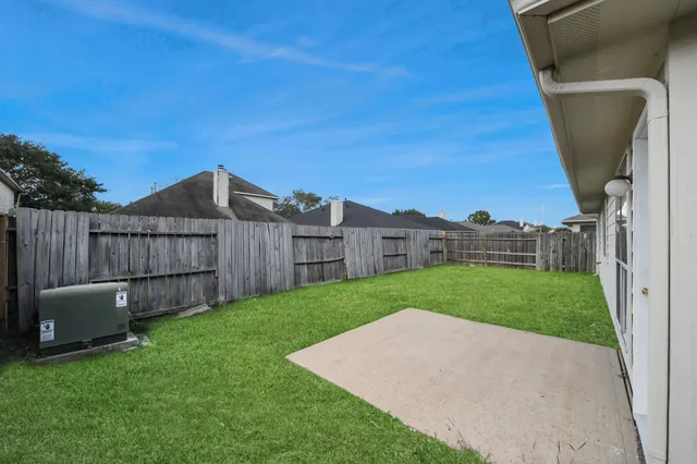 a view of a backyard with wooden fence