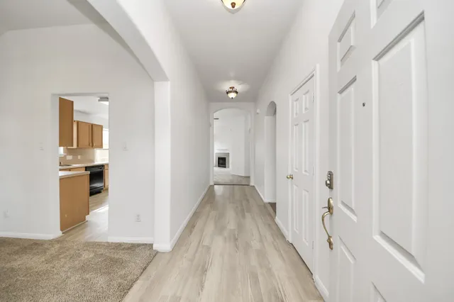 a view of a hallway with wooden floor and staircase
