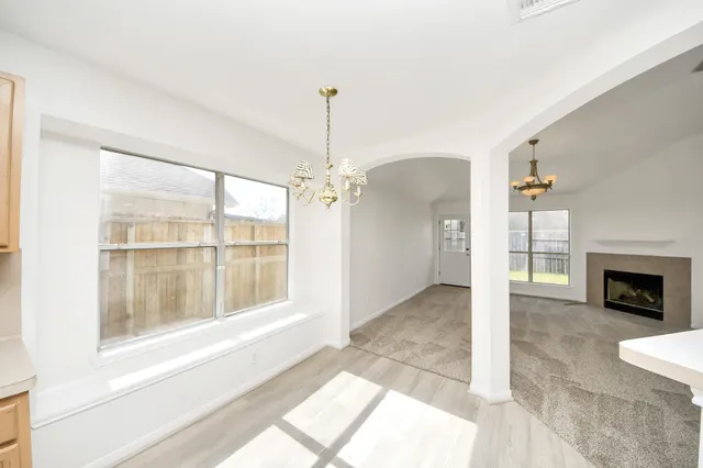a view of an empty room with a fireplace and a window