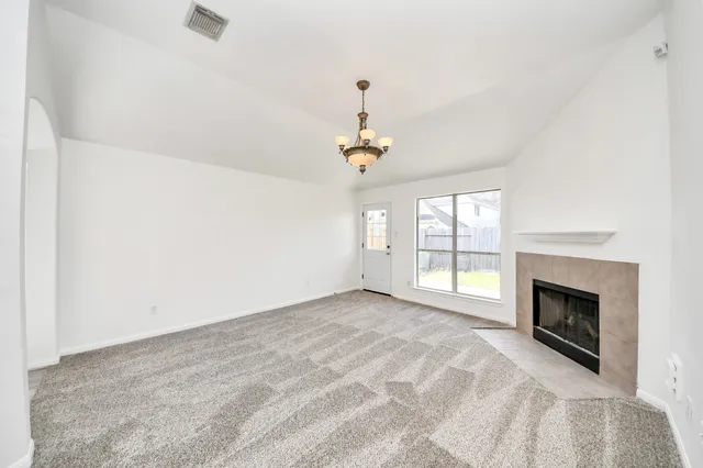 a view of an empty room with a fireplace and a window