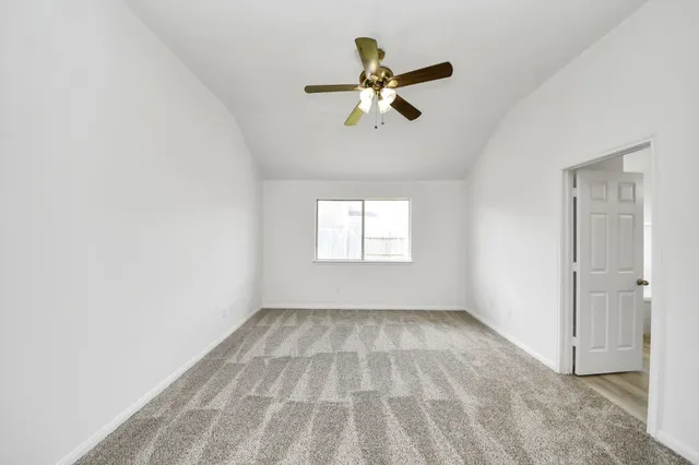 an empty room with fan and windows