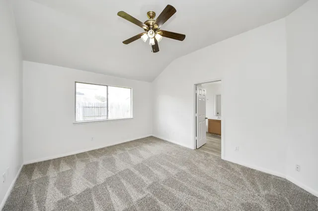 an empty room with a window and a fan