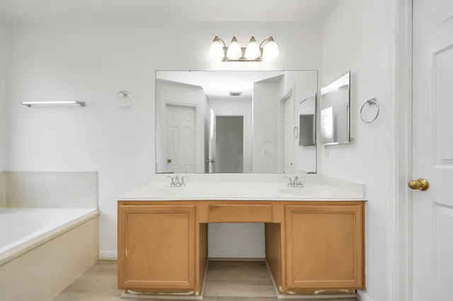 a bathroom with a tub sink and mirror