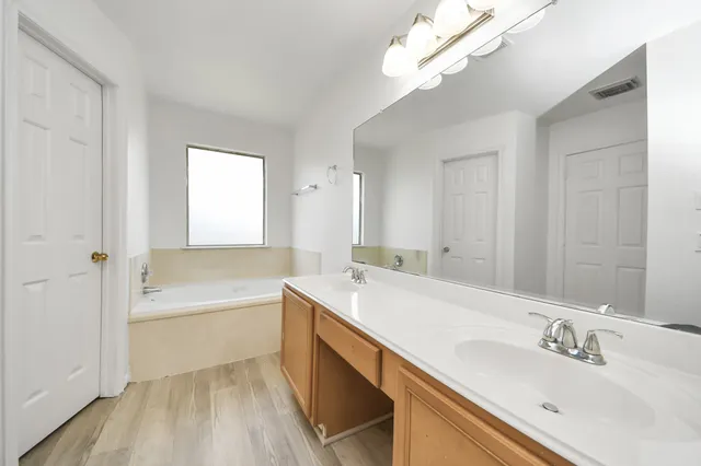 a bathroom with a double vanity sink mirror and shower