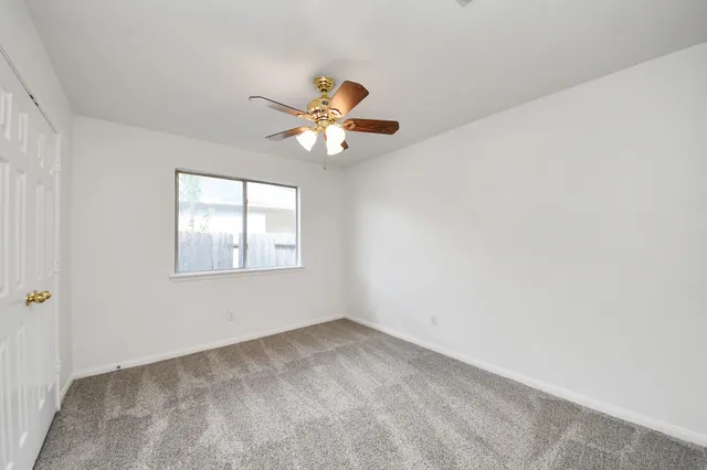 a view of a livingroom with a ceiling fan and window