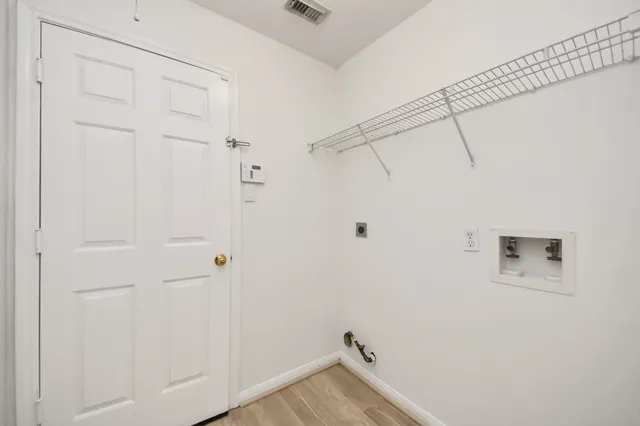 an empty room with windows and fireplace