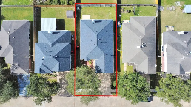 an aerial view of a house with a yard and a large tree