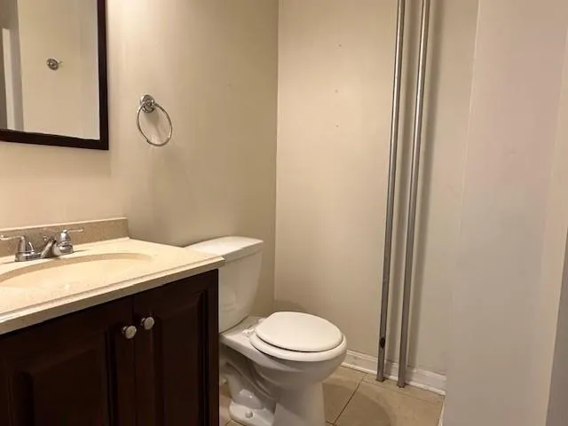 a bathroom with a granite countertop sink mirror vanity and toilet