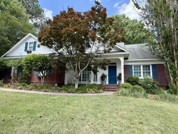 a front view of a house with a garden