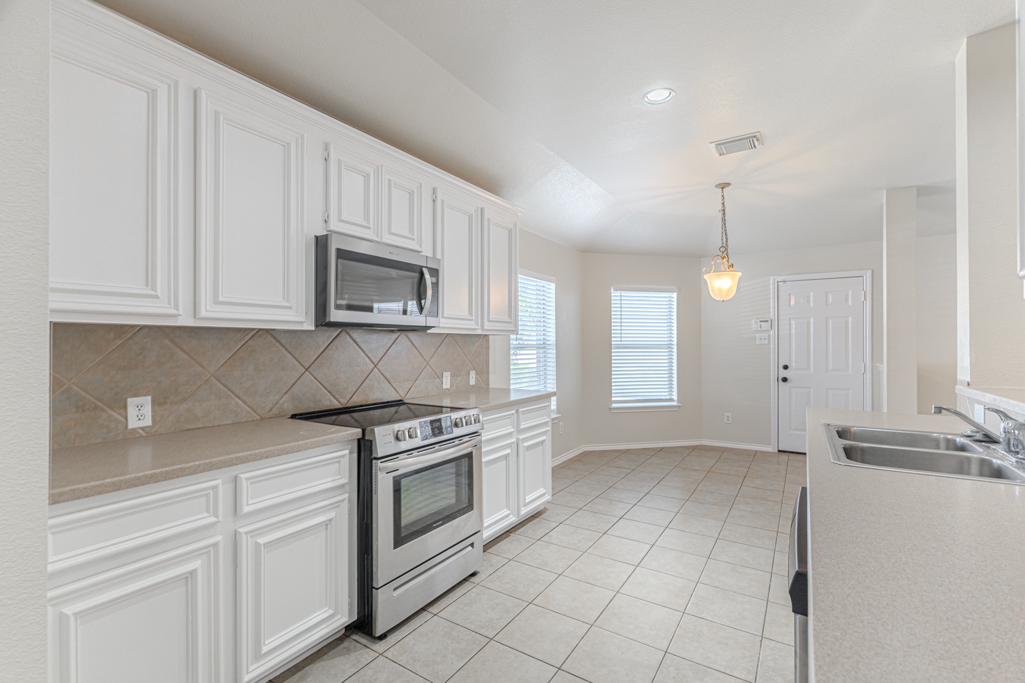 25506 Brisk Spring Court Spring, TX 77373 - Photo 19 of 45 a kitchen with stainless steel appliances granite countertop white cabinets and window