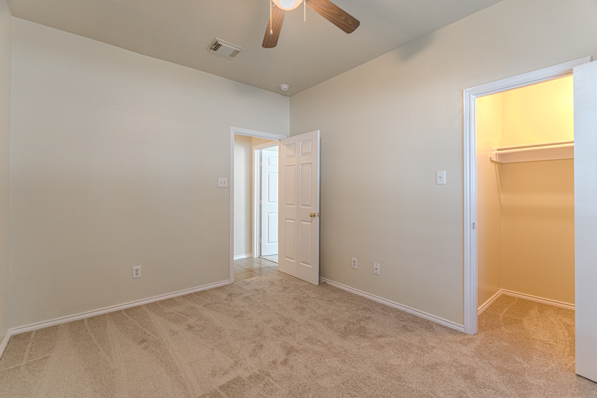 25506 Brisk Spring Court Spring, TX 77373 - Photo 31 of 45 an empty room with a chandelier fan and windows