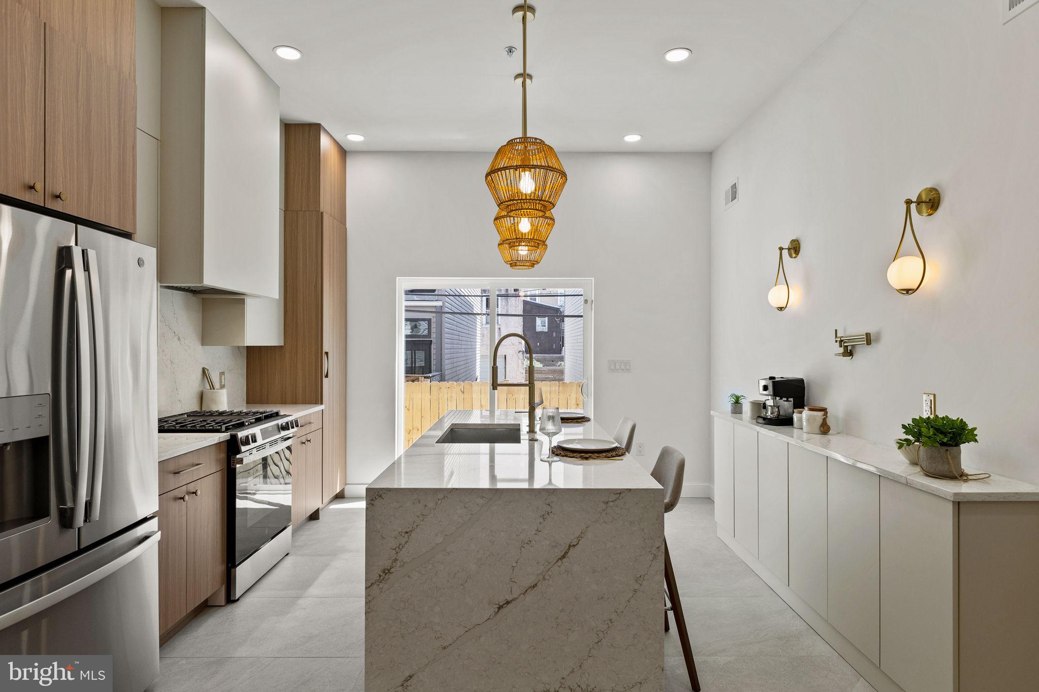 a kitchen with stainless steel appliances granite countertop a sink a refrigerator and a stove