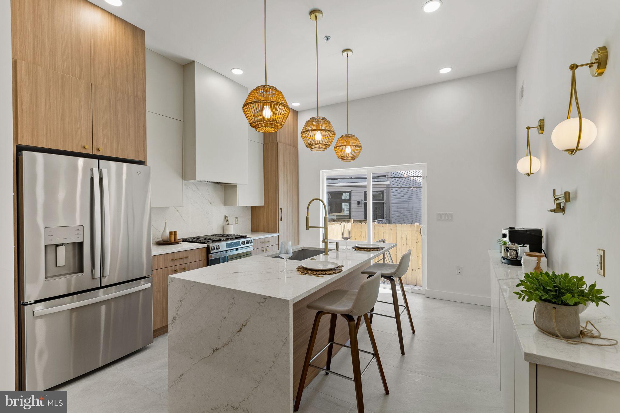 1709 North 4th Street Philadelphia, PA 19122 - Photo 12 of 50 a kitchen with stainless steel appliances granite countertop a stove a refrigerator a oven a sink a dining table and chairs with wooden floor