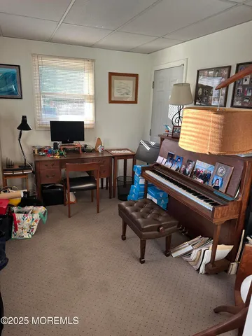 a living room with furniture a piano and a window