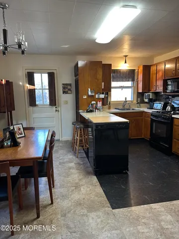 a kitchen with kitchen island granite countertop a sink counter top space appliances and cabinets