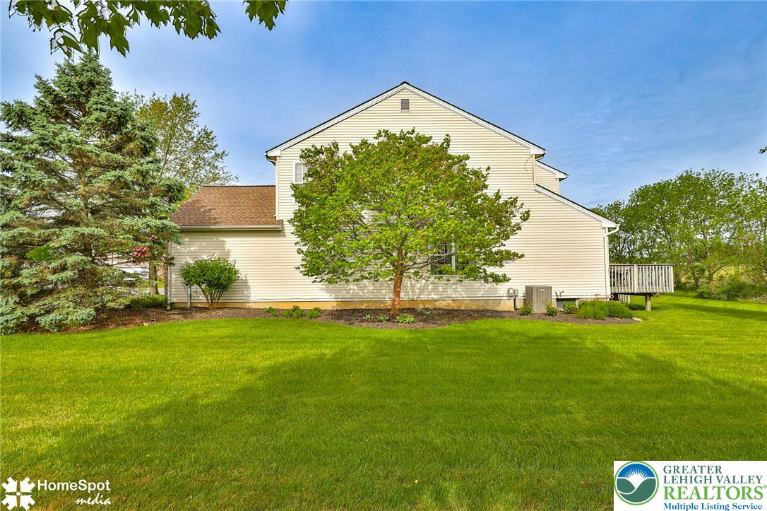 4191 Walter Road Bethlehem, PA 18020 - Photo 19 of 23 A pristine backyard lawn stretches to meet the home's rear, featuring a modest deck.