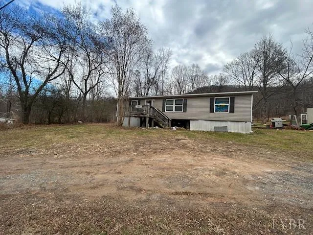 a view of house with backyard and trees