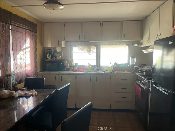 a kitchen with granite countertop a sink cabinets stainless steel appliances and a window