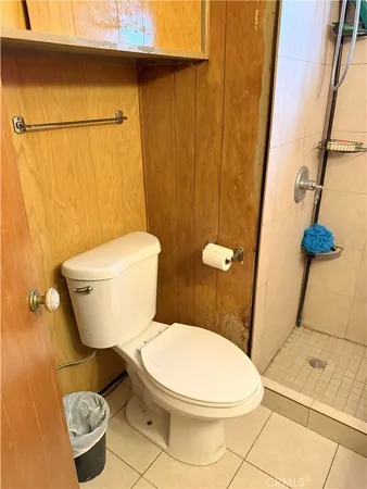 a white toilet sitting next to a bath tub and a shower