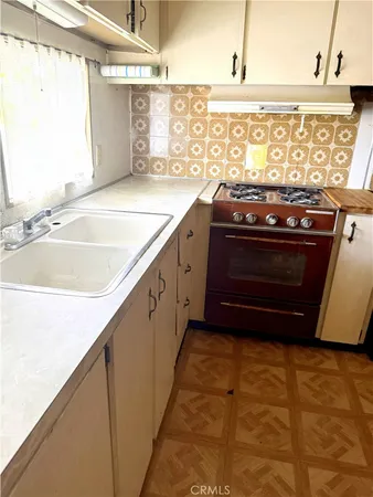 a view of kitchen with granite countertop stove top oven and cabinets