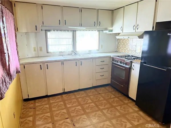 a kitchen with granite countertop white cabinets and refrigerator