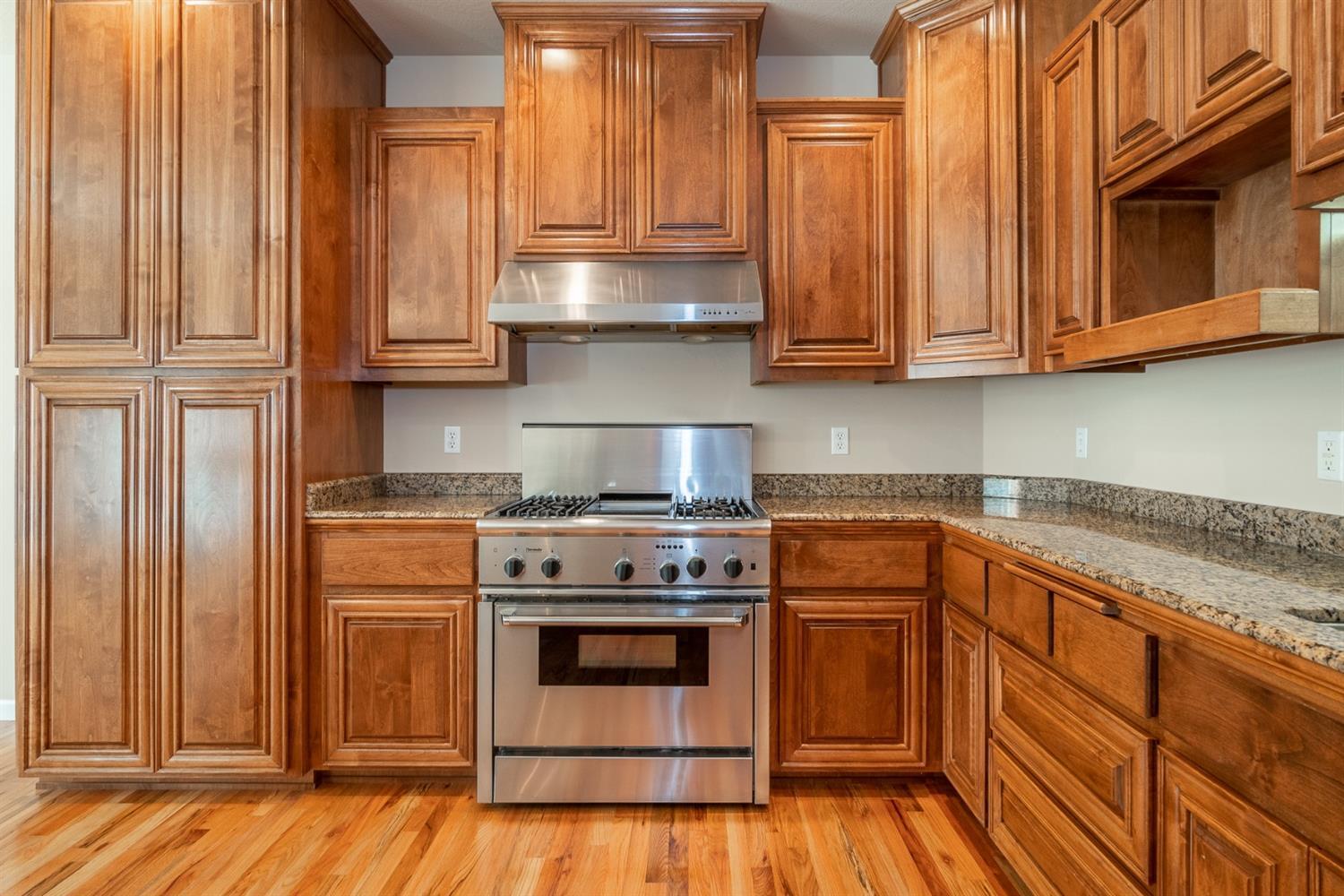 946 Pumpkin Ridge Eagle Point, OR 97524 - Photo 24 of 31 a kitchen with wooden cabinets and a stove top oven
