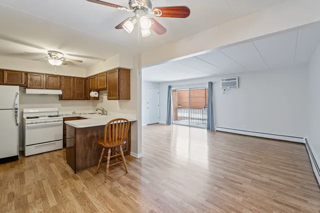 a kitchen with a table chairs refrigerator and cabinets
