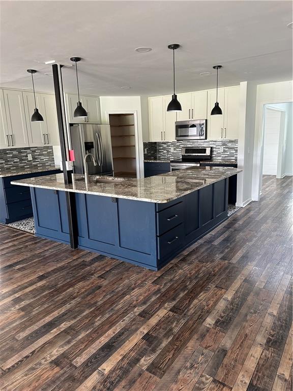 500 Coleman Mill Road Carrollton, GA 30116 - Photo 9 of 83 a kitchen with stainless steel appliances kitchen island granite countertop a sink and a wooden floor