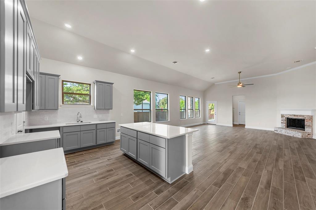 2201 Uhl Road Glenn Heights, TX 75154 - Photo 8 of 22 Kitchen featuring gray cabinetry, white countertops, tile backsplash, and a central island