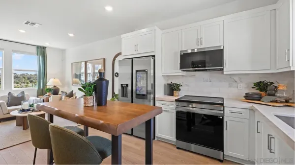 a kitchen with stainless steel appliances stove microwave refrigerator dining table and chairs