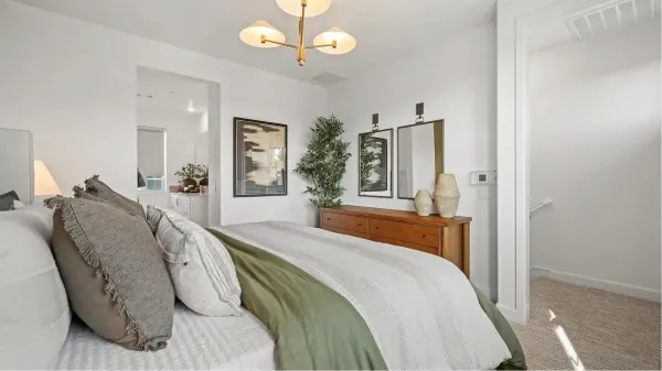 a spacious bedroom with a bed mirror and painting on the wall