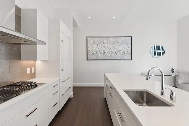 a kitchen with white cabinets a sink dishwasher and stove