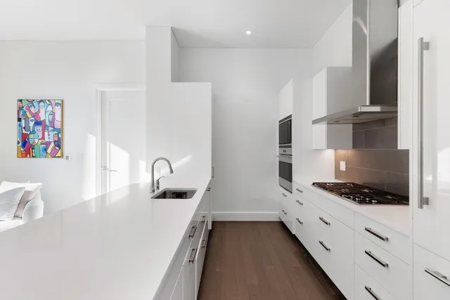 a kitchen with granite countertop a sink and a stove top oven