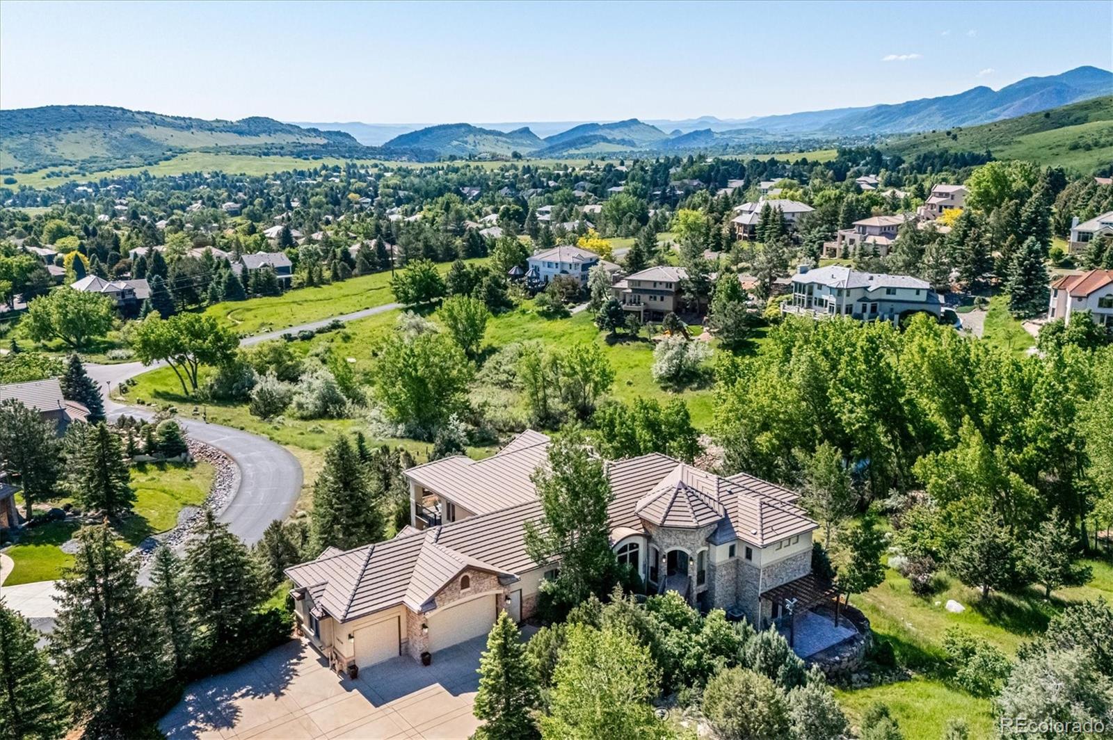 an aerial view of a city with lots of residential buildings and mountain view in back