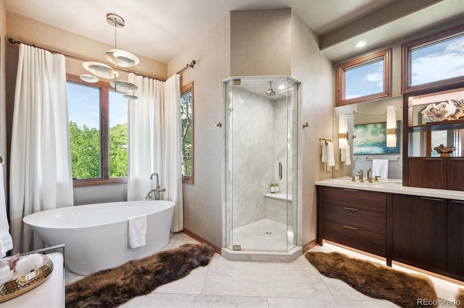 16134 Sandstone Drive Morrison, CO 80465 - Photo 14 of 30 a bathroom with a tub shower sink and mirror