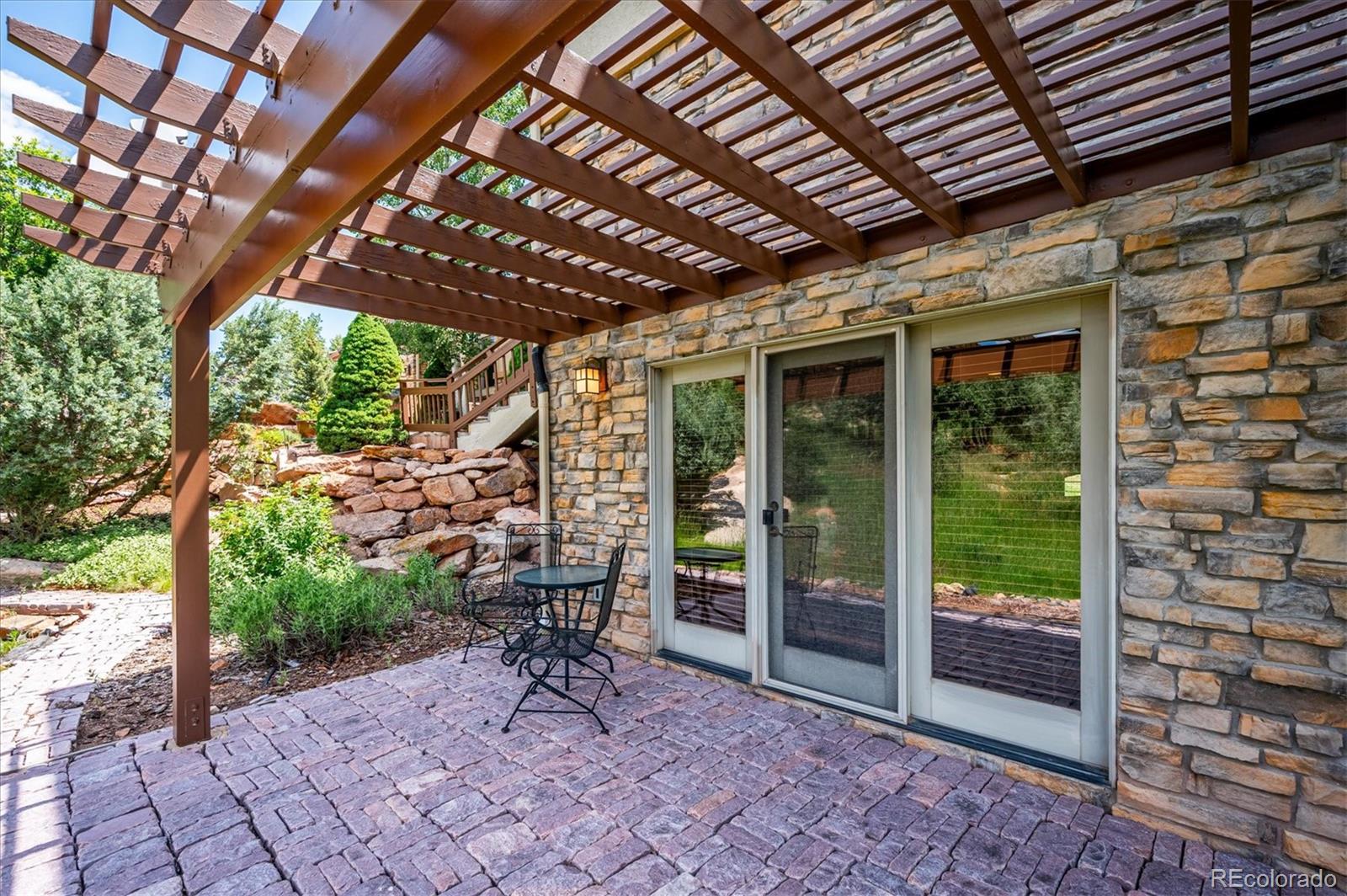 16134 Sandstone Drive Morrison, CO 80465 - Photo 22 of 30 a view of a porch with furniture and a yard