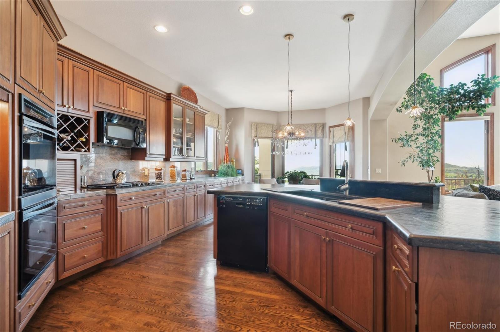 16134 Sandstone Drive Morrison, CO 80465 - Photo 9 of 30 a kitchen with stainless steel appliances granite countertop wooden cabinets a sink dishwasher a stove and a refrigerator