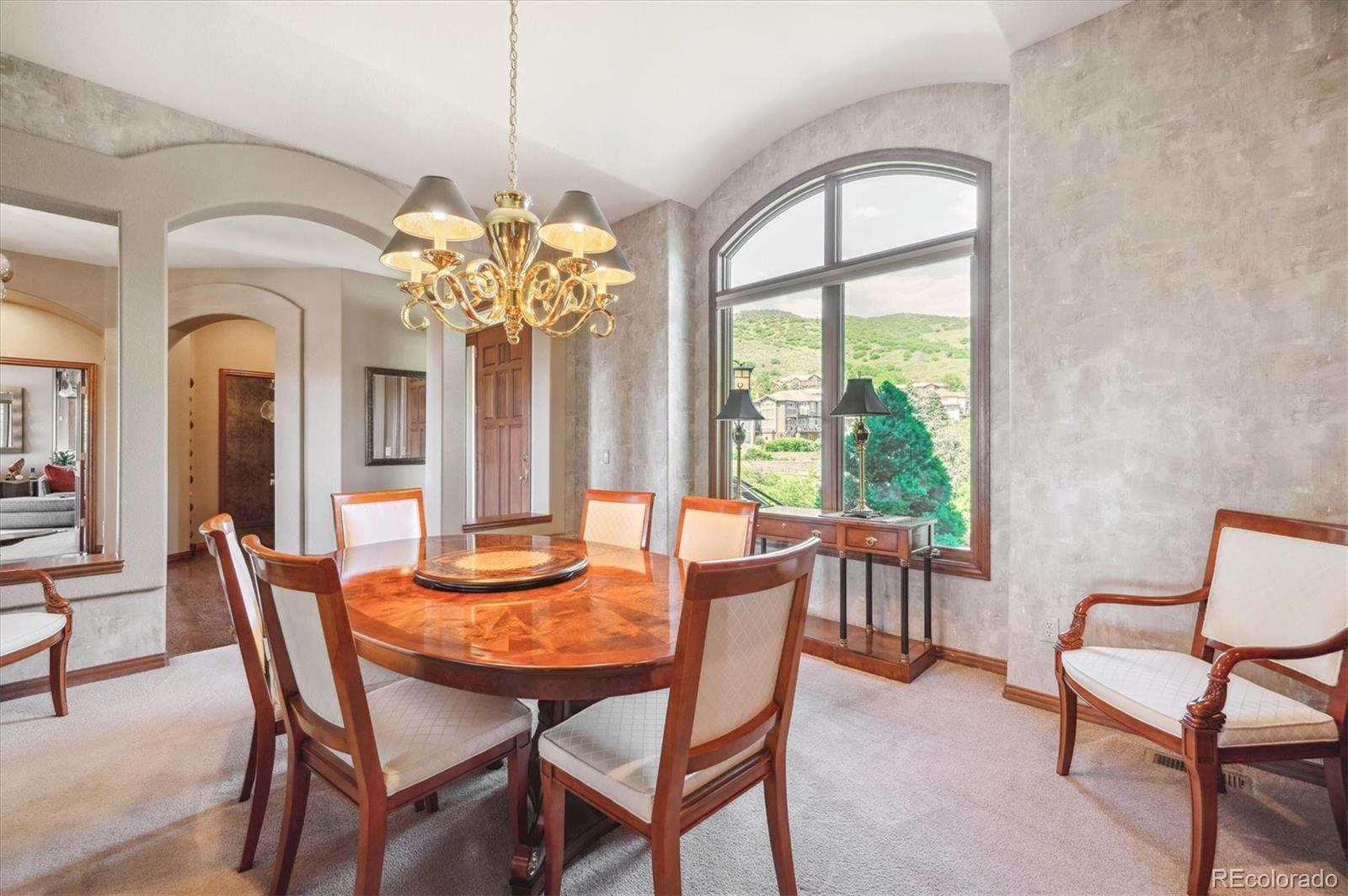 16134 Sandstone Drive Morrison, CO 80465 - Photo 10 of 30 a dining room with furniture a chandelier and a rug