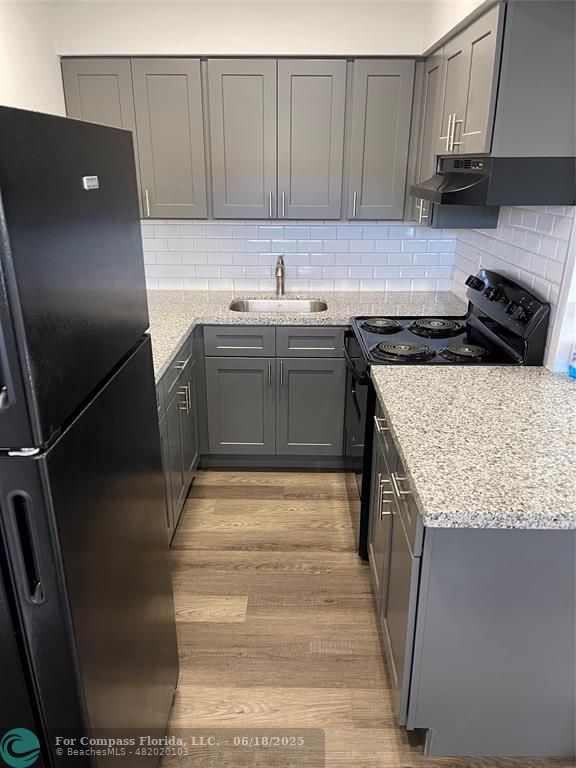 5631 Northwest 15th Street Lauderhill, FL 33313 - Photo 14 of 20 a kitchen with a sink refrigerator and cabinets