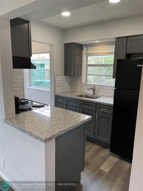 5631 Northwest 15th Street Lauderhill, FL 33313 - Photo 15 of 20 a kitchen with stainless steel appliances granite countertop a sink stove and refrigerator