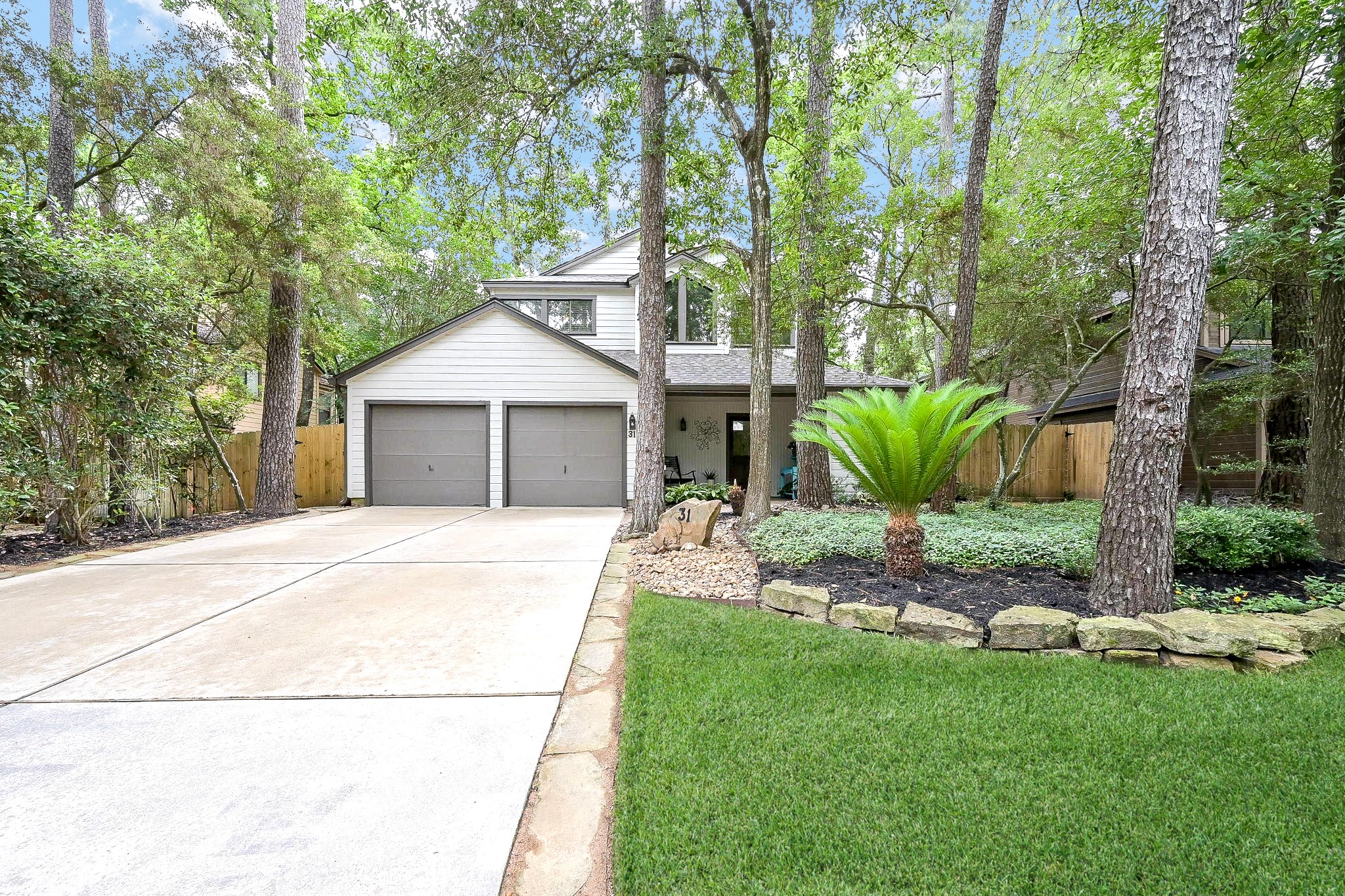 This charming home features a two-car garage and is nestled among mature trees, offering a serene, wooded setting. The well-maintained front yard includes lush greenery and a quaint pathway leading to the entrance. Perfect for nature lovers seeking​​‌​​​​‌​​‌‌​‌‌​​‌​​​​‌​​​‌‌​‌‌‌ tranquility.