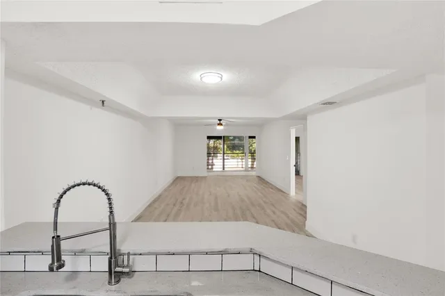 a view of empty room with wooden floor and window