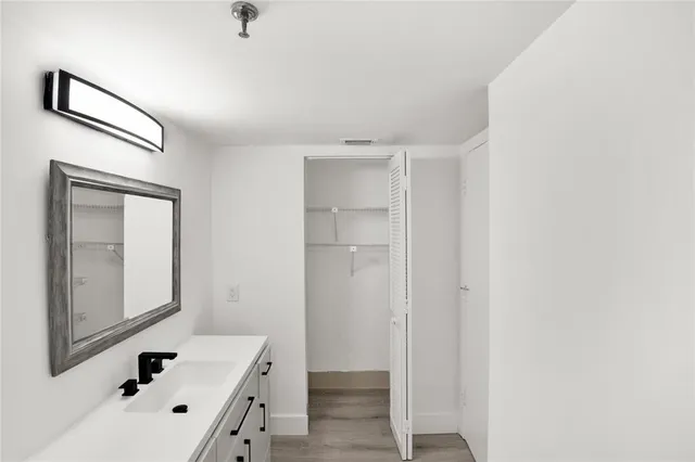 a bathroom with a sink mirror and tub