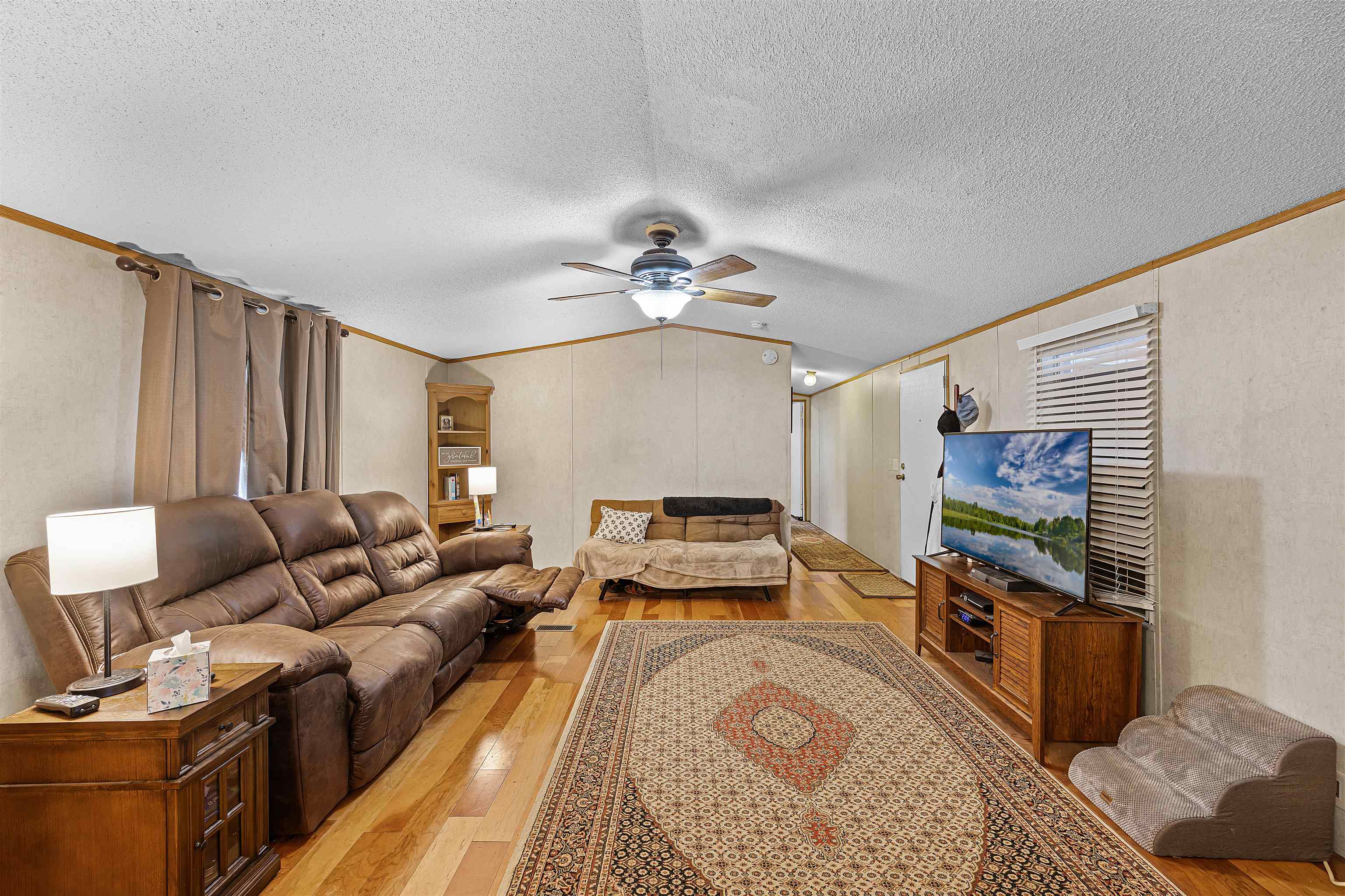 90 Rose Road Crump, TN 38327 - Photo 14 of 28 Living area featuring light wood-style floors, ornamental molding, ceiling fan, and a textured wall