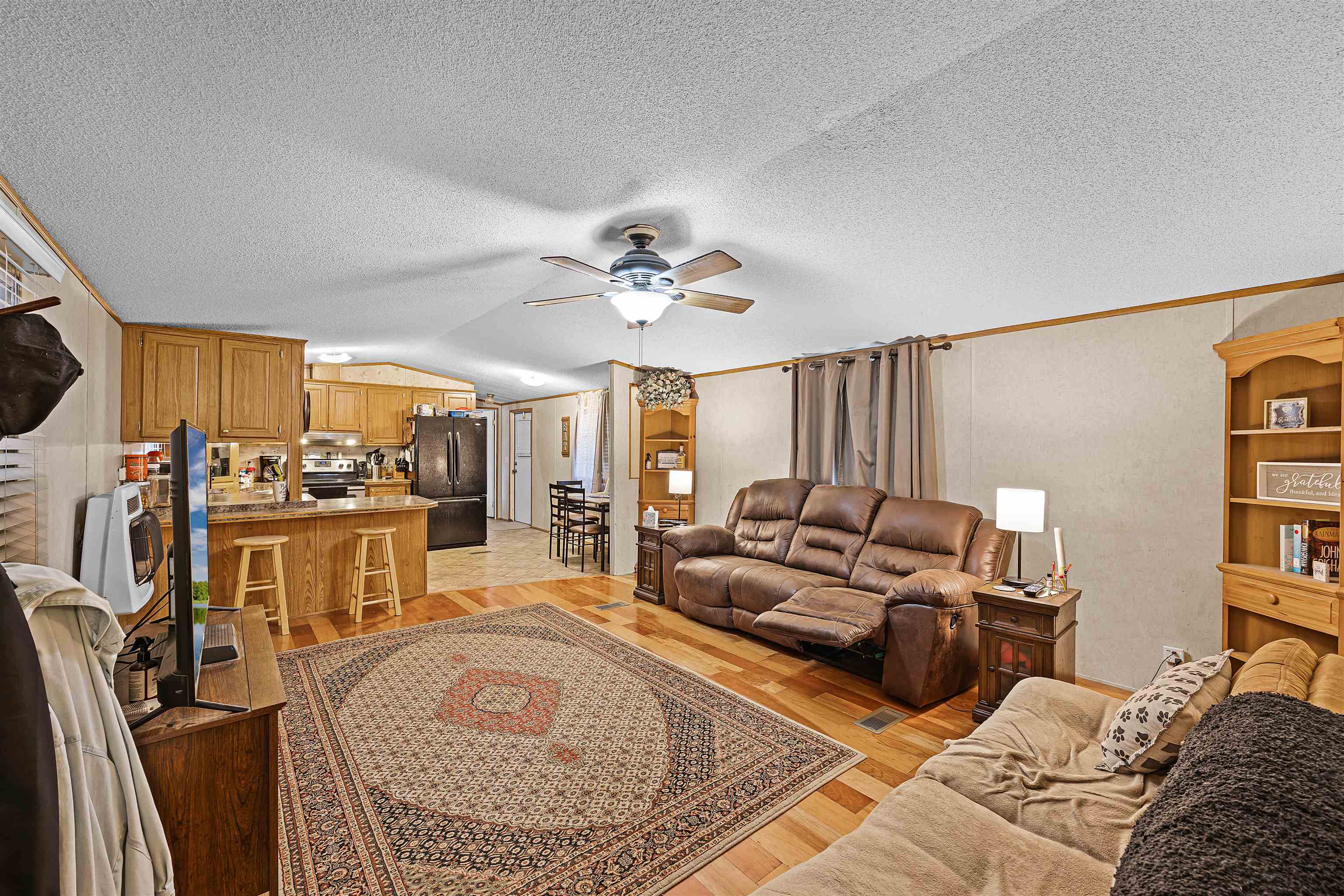 90 Rose Road Crump, TN 38327 - Photo 16 of 28 Living area with light wood-type flooring, heating unit, a ceiling fan, and crown molding