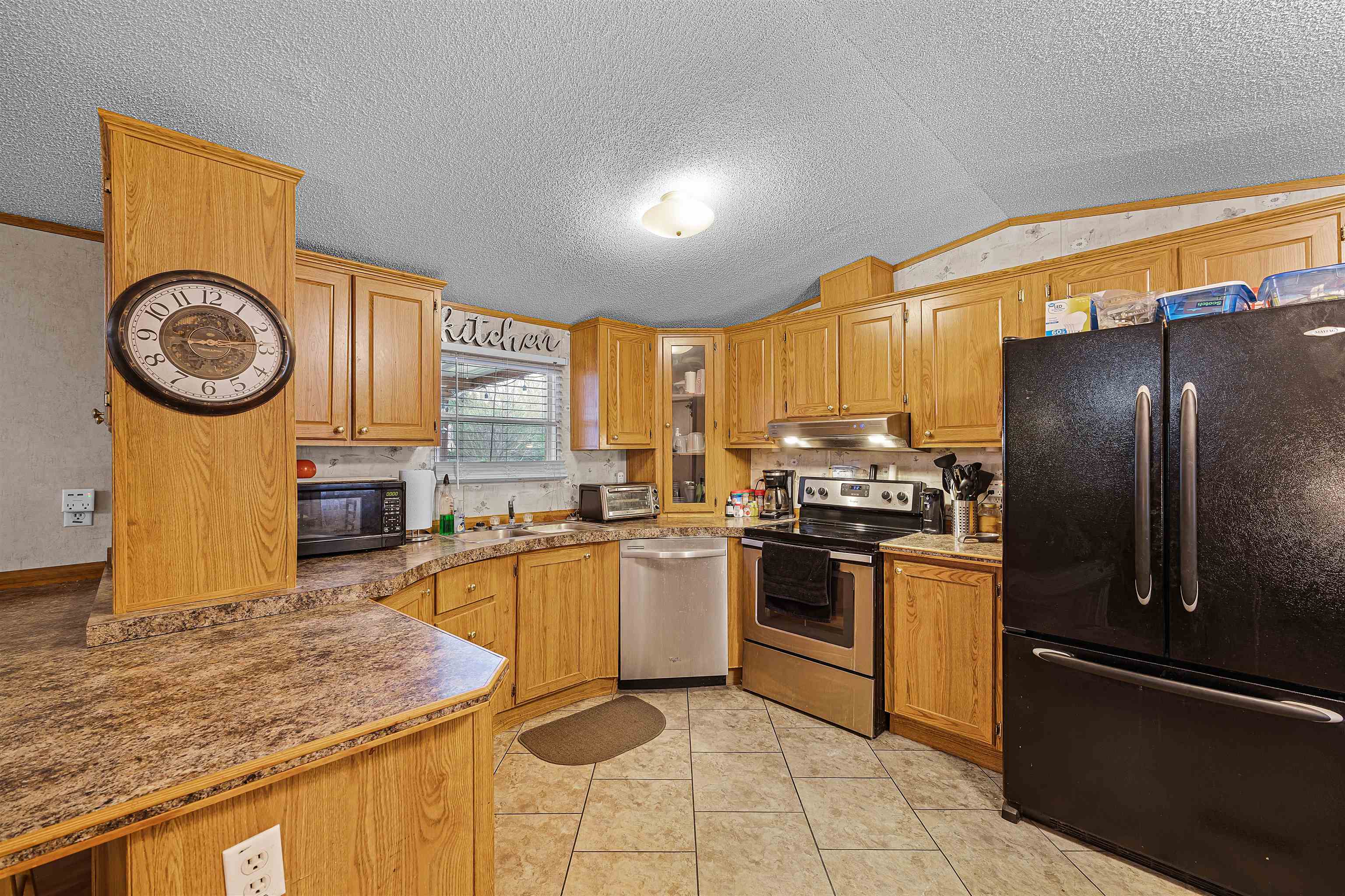 90 Rose Road Crump, TN 38327 - Photo 18 of 28 Kitchen with black appliances, light tile patterned flooring, and wood finish cabinets