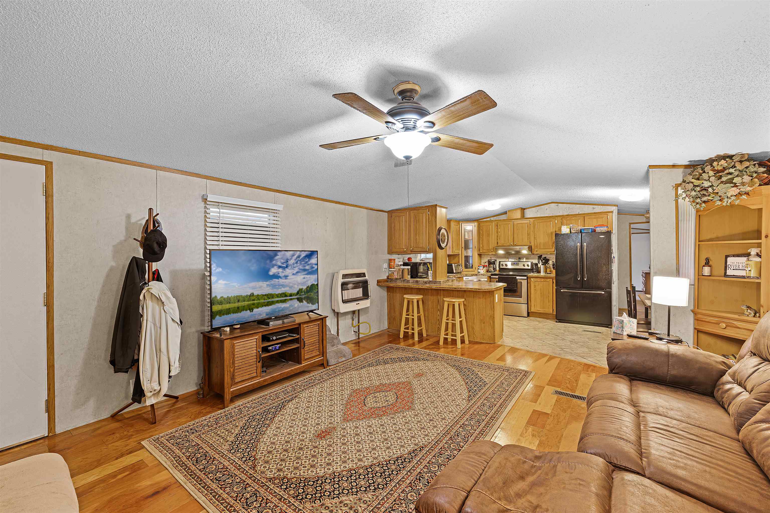 90 Rose Road Crump, TN 38327 - Photo 2 of 28 Living area with light wood-type flooring, a ceiling fan, heating unit, and crown molding