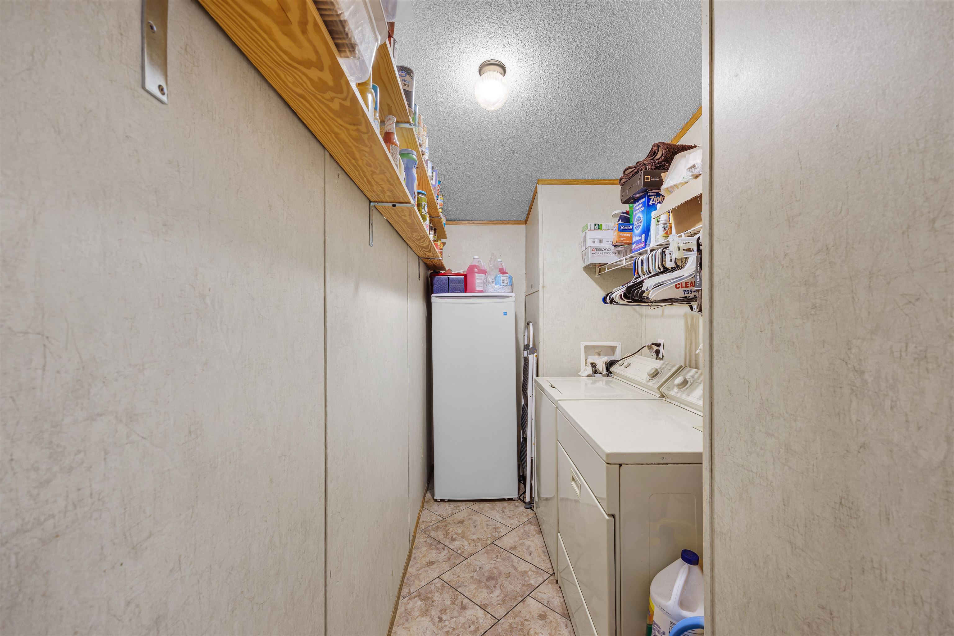 90 Rose Road Crump, TN 38327 - Photo 9 of 28 Laundry room with a textured ceiling, separate washer and dryer, and light tile patterned floors
